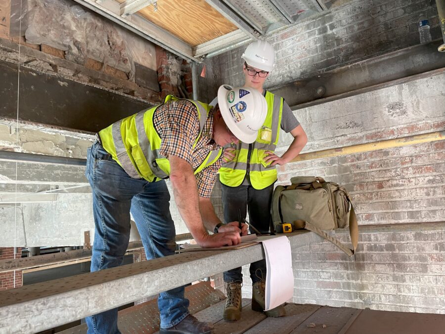 PMA Engineering Vice President Jeff Patterson jots down measurements while intern Ben Pennington observes.